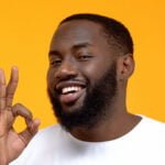 Handsome Afro-American man showing OK sign, customer review, friendly service